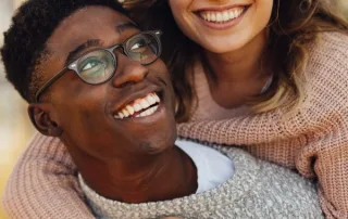 A young man gives a young woman a piggyback ride.