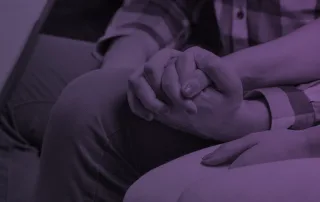 Two people holding hands while in couples therapy.
