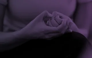 A woman fiddles with her hands while experiencing anxiety.