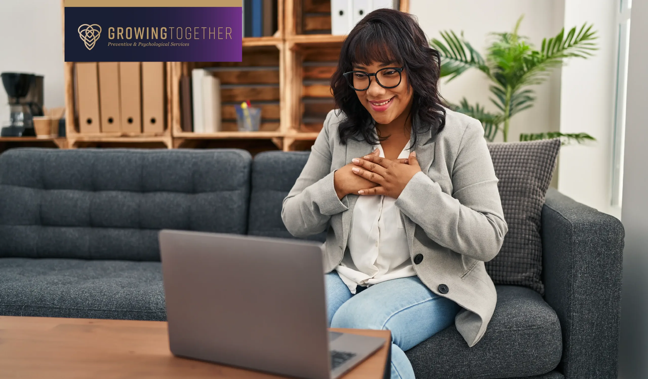 A woman sits in front of a laptop while attending online therapy.