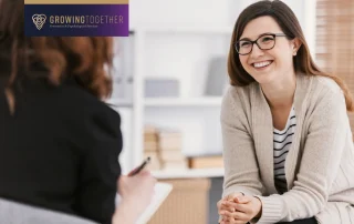 Happy woman during successful psychotherapy with counselor at clinic.